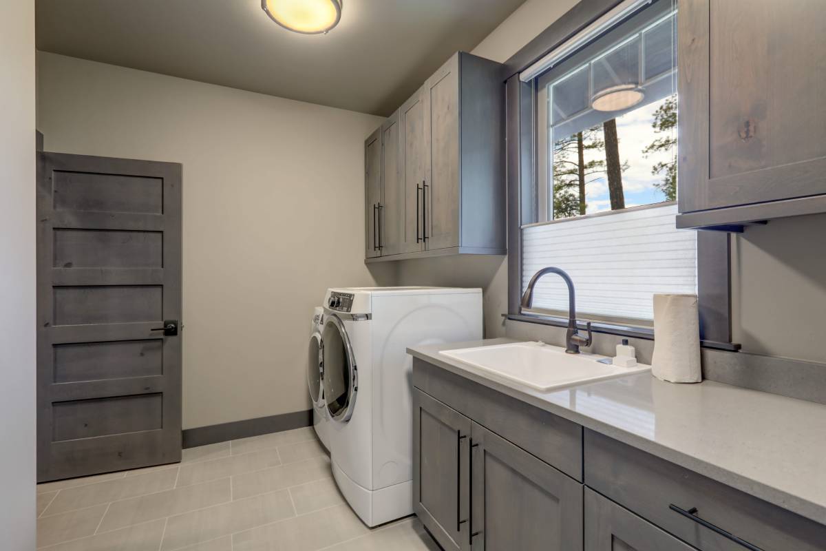 Laundry room window treatments on a window above a utility sink in a minimalist space at Signature Shutters & Blinds near Dayton, OH