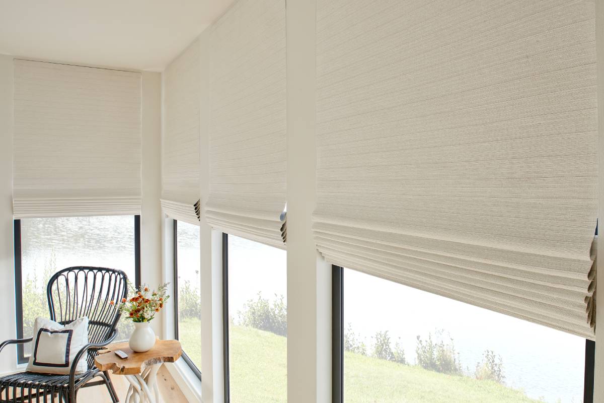 Graber® Natural Woven Shades in a light fabric on large windows in a sitting room
