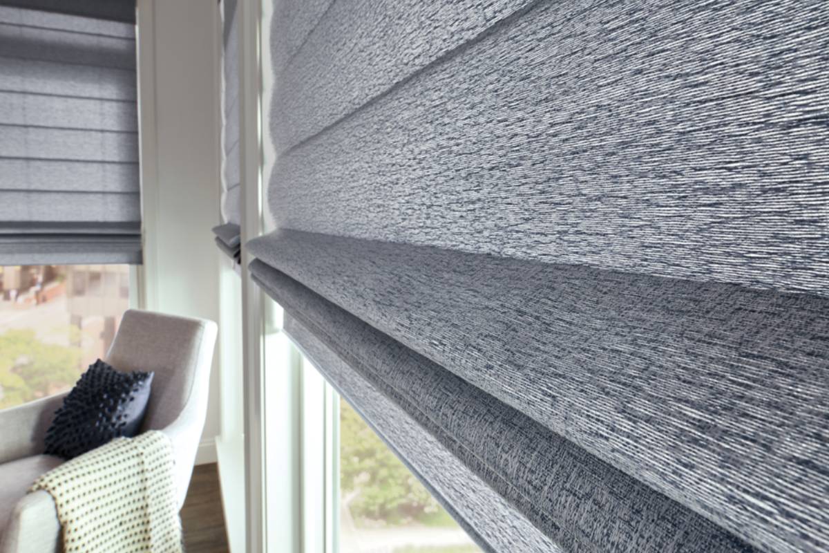 Stunning Graber® Roman Shades in a textured fabric in a home's stylish sitting area