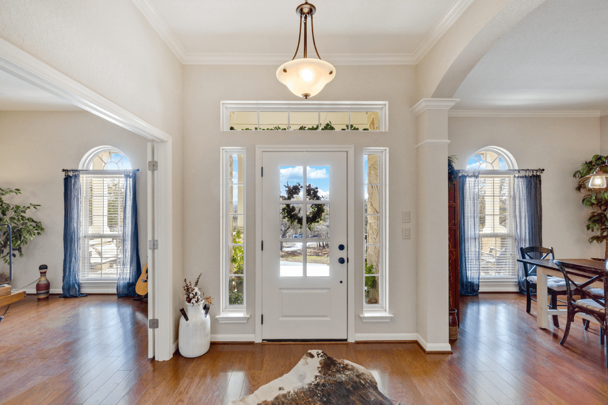 An entryway featuring a front door with sidelight in need of covering for light control